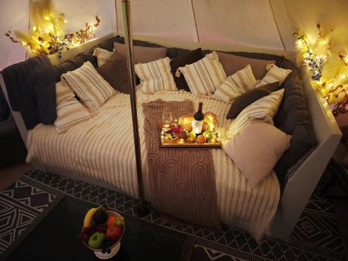 a large bed with a tray of fruit on it at Paradise Gardens Glamping in Westville