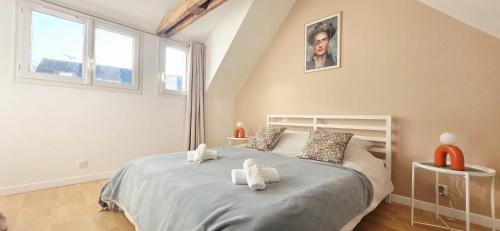 Duplex Saint-Martin في جوسلين: غرفة نوم بها سرير عليه دميتان محشوتان