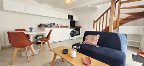 een woonkamer met een blauwe bank en een tafel bij Duplex Saint-Martin in Josselin