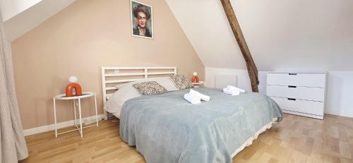 een slaapkamer met een bed en 2 witte handdoeken bij Duplex Saint-Martin in Josselin