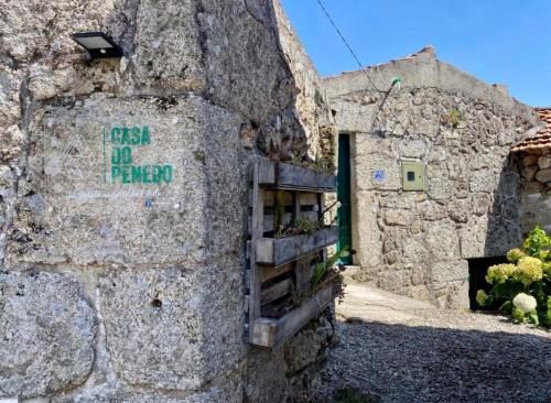 a stone building with a sign on the side of it at CASA DO PENEDO - Um Segredo na Serra da Estrela in Linhares