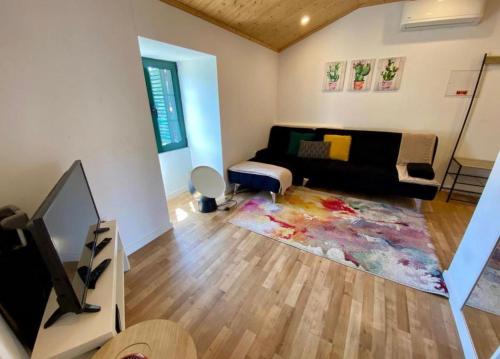 a living room with a couch and a tv at CASA DO PENEDO - Um Segredo na Serra da Estrela in Linhares