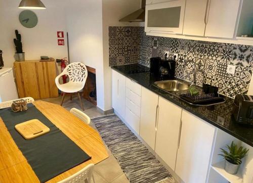 a kitchen with a table and a sink in it at CASA DO PENEDO - Um Segredo na Serra da Estrela in Linhares
