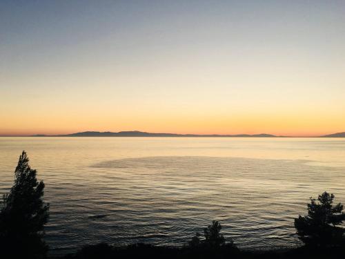 a sunset over a large body of water at Sea Horizon Private Villa with Panoramic Sea Views in Nea Skioni