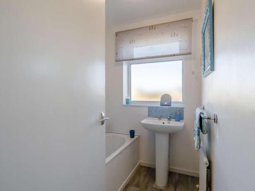 a bathroom with a sink and a bath tub and a window at 2 Bed in Seahouses oc-86092 in North Sunderland