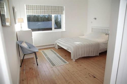 une chambre avec un lit, une chaise et une fenêtre dans l'établissement 3 Bed in Gower oc-hh2105, à Rhossili