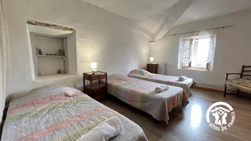 een slaapkamer met twee bedden en een spiegel bij Chateau st-auriol - le caviste in Saint-Pierre-des-Champs