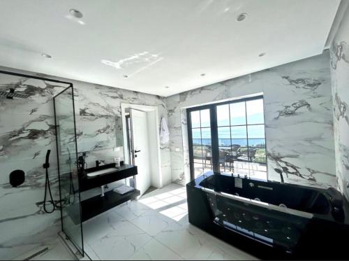 a bathroom with a tub and a glass shower at Bella Vista Rezidence in Pogradec