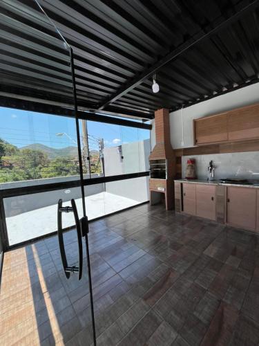 een grote keuken met een groot raam met uitzicht bij AP Quatro Estações in Miguel Pereira