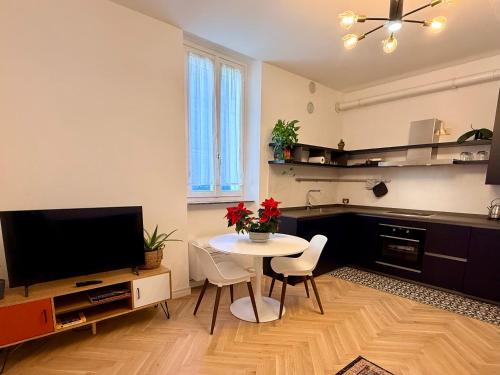 ein Wohnzimmer mit Tisch und Fernseher in der Unterkunft WANDERLUST Splendido appartamento in centro in Pavia