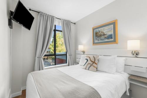 une chambre blanche avec un lit et une fenêtre dans l'établissement Alpenglow Lodge Junior One Bedroom by MVA, à Whistler