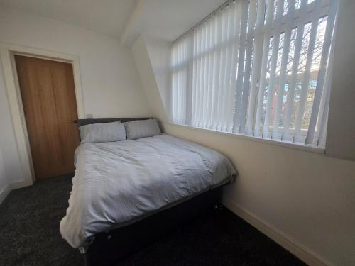 a small bed in a room with a window at 1 Bed City Centre Apartment in Derby