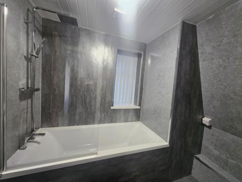a bathroom with a bath tub and a window at 1 Bed City Centre Apartment in Derby