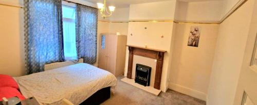 een slaapkamer met een bed en een open haard bij Premium Stay Experience in Bristol