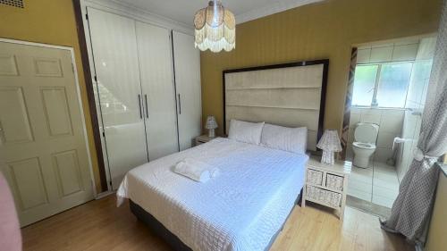 una camera da letto con un letto bianco e un bagno di 3 Bed - Modern Retreat with Stay-in helper a Bloemfontein
