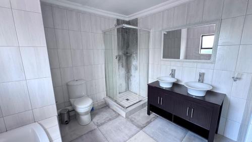 un bagno con doccia, lavandino e WC di 3 Bed - Modern Retreat with Stay-in helper a Bloemfontein