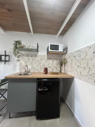 een keuken met een zwarte koelkast en een magnetron bij Bujanvilla in Tarifa