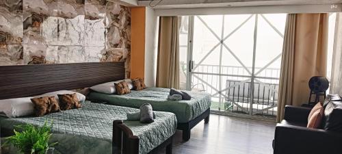 a bedroom with two beds and a large window at SUITE EN TORRES GEMELAS a pie de playa 1403 N in Acapulco