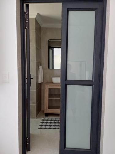 d'une salle de bains avec une porte s'ouvrant sur une salle de bains pourvue d'un lavabo. dans l'établissement Cosy comfort, à George