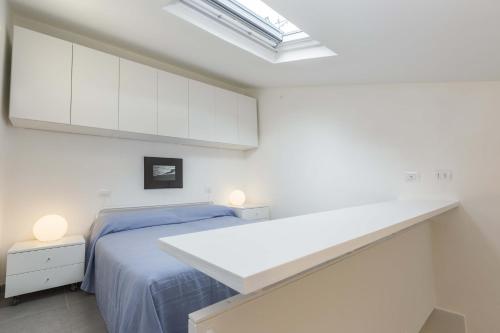 una camera con letto e armadi bianchi di I Chioppi 6 - Goelba a Capoliveri