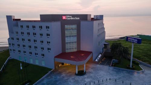 a hotel building with a sign on top of it at Hilton Garden Inn Veracruz Boca del Rio in Veracruz
