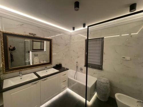 a bathroom with a tub and a sink and a mirror at Dom Berry in Chrzanow