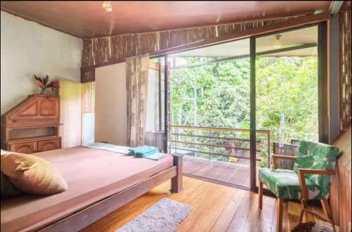 a bedroom with a bed and a balcony at Orgánico Punta Riel in Cahuita
