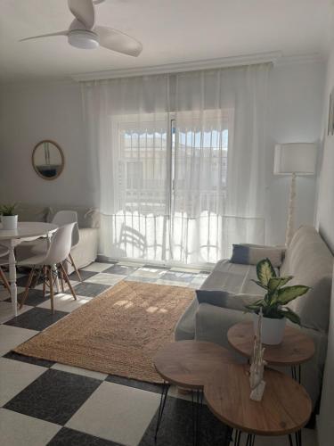 een woonkamer met een bank en een tafel bij Apartamento Clavel in Chipiona