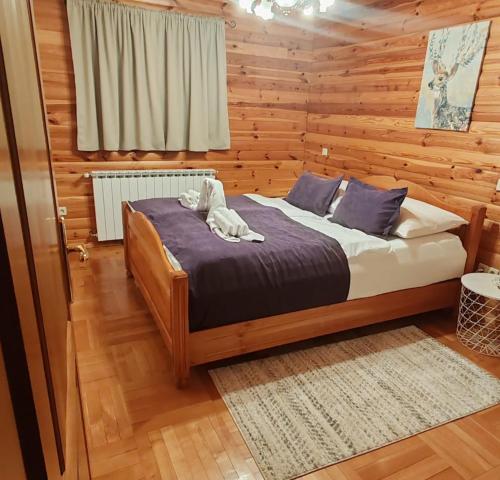 a bedroom with a bed in a wooden room at Greenhouse Klara with heated pool in Tršće