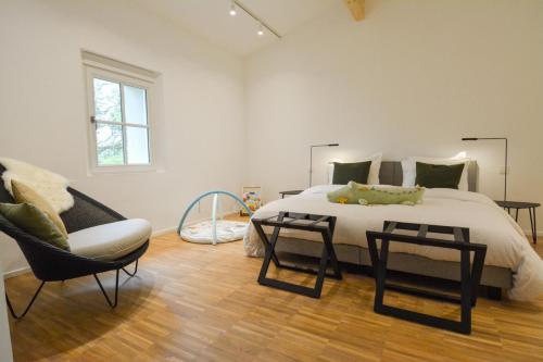 a bedroom with a large bed and a chair at Le domaine de rigou in Lasbordes