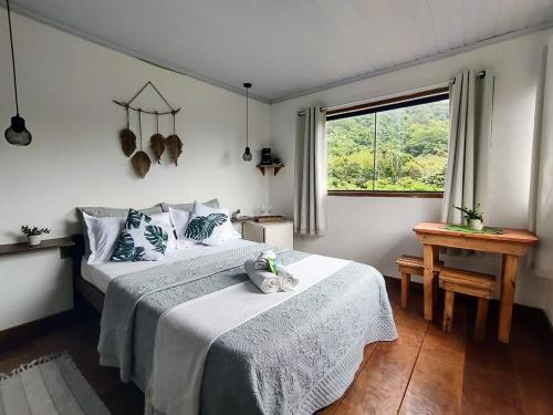 a bedroom with two beds and a window at Suites casa do indio jungle, a melhor vista da floresta in Abraão
