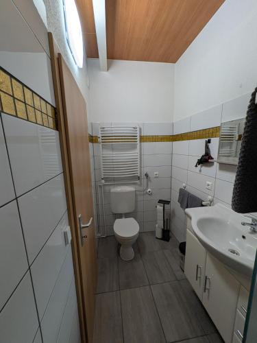 a white bathroom with a toilet and a sink at Air 41 in Konstanz