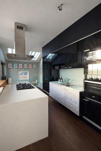 a large kitchen with a white counter top and black cabinets at Manchesters Ultimate House - Hot tub - Sleeps 22! in Manchester