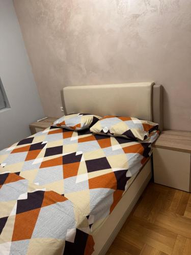 a bedroom with a bed with a colorful quilt at Vila Ljubovic in Podgorica