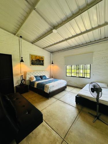 a large room with two beds and a couch in it at Finca el origen in Roldanillo