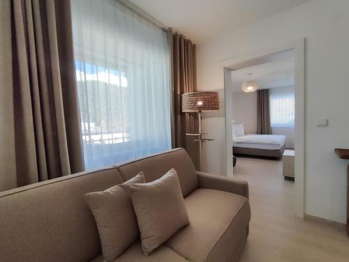 een woonkamer met een bank en een groot raam bij das Alpenblick & Outdoor Lodge Nauders in Nauders