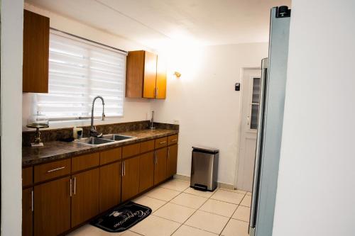 a kitchen with wooden cabinets and a sink and a window at Alojamiento completo familiar in Carolina