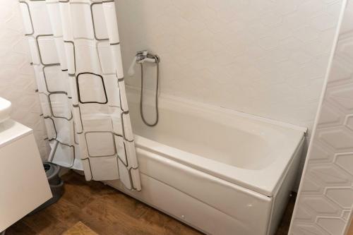 een wit bad met een douchegordijn in de badkamer bij Apartman Nana in Vranje