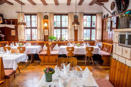 a restaurant with white tables and chairs and windows at Hotel-Restaurant & Metzgerei Rößle in Dettingen an der Erms