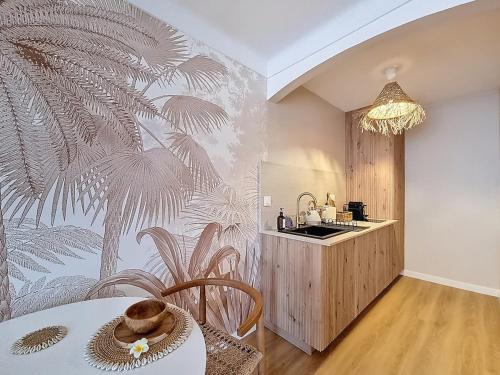 una cucina con un murale di palme di La Suite BALI, Charme et Confort, Hyper centre a La Roche-sur-Yon