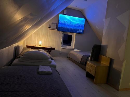 a bedroom with two beds and a flat screen tv at Ader puhkemaja in Kogula