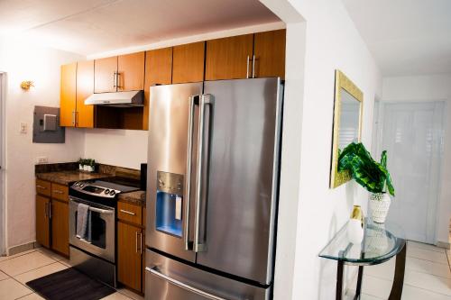 a kitchen with a stainless steel refrigerator and wooden cabinets at Alojamiento completo familiar in Carolina