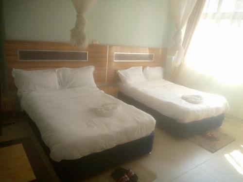 two twin beds in a room with a window at Dagmaros in Bahir Dar