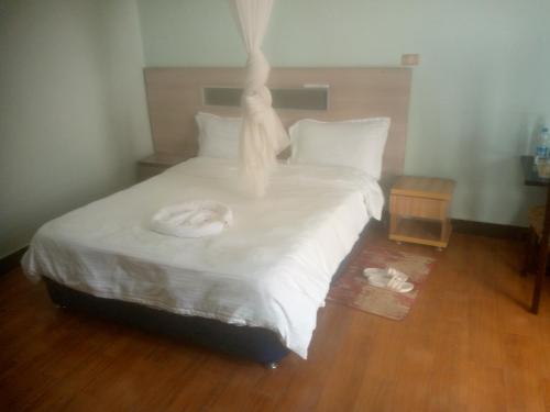a bed with white sheets and white towels on it at Dagmaros in Bahir Dar