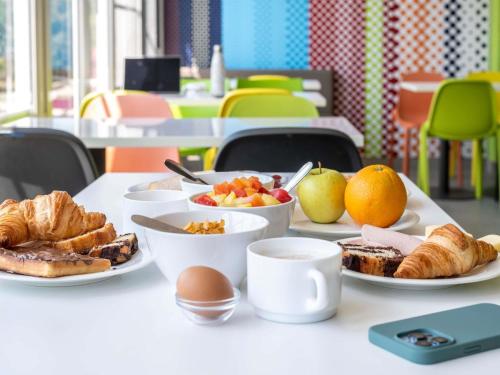 a table with plates of breakfast food on it at ibis budget Strasbourg Sud Illkirch in Geispolsheim