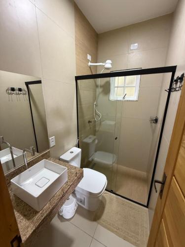 een badkamer met een wastafel, een toilet en een douche bij Suites do Félix in Ubatuba