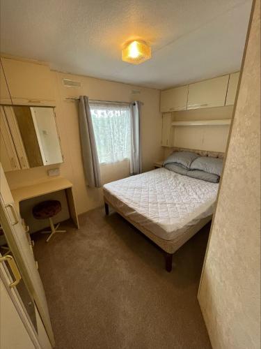 a small bedroom with a bed and a desk at Southview Holiday Park in Winthorpe