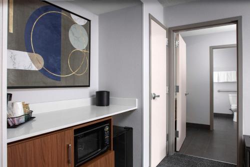 een keuken met een magnetron en een schilderij aan de muur bij Courtyard by Marriott Richmond Northwest in Henrico