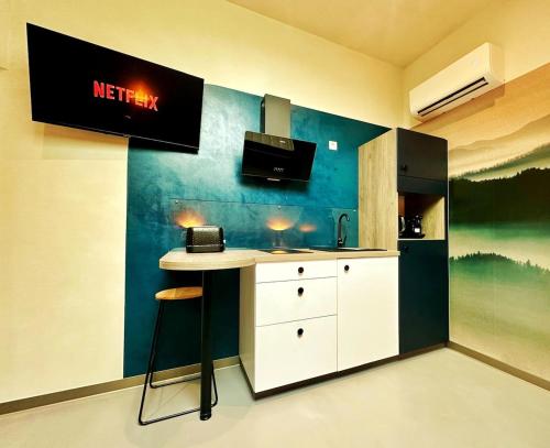 a kitchen with a counter with a sink and a refrigerator at L'annexe 3 - Cosy studio Dole in Foucherans