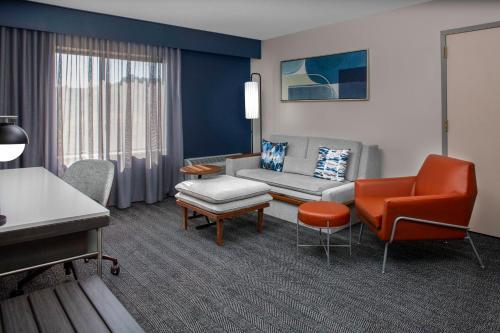 een woonkamer met een bank en een stoel bij Courtyard by Marriott Richmond Northwest in Henrico